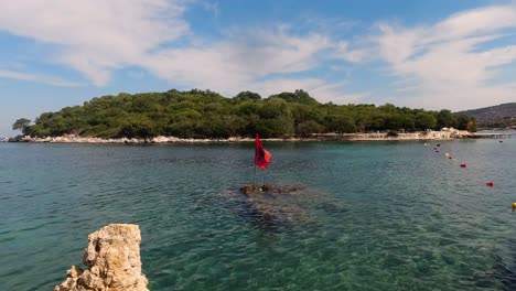 Albanian-flag-waving-at-famous-Ksamil-Islands-in-summer
