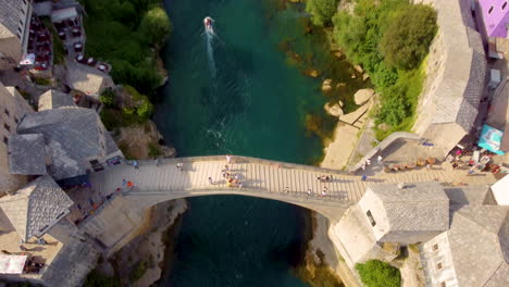 Drohne-In-Richtung-Der-Gewölbten-Steinbrücke-über-Den-Fluss-Neretva-In-Der-Stadt-Mostar,-Bosnien-Und-Herzegowina