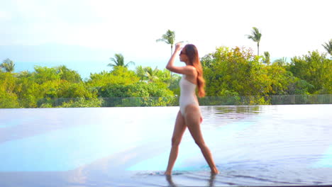 Beautiful-and-charming-woman-walking-on-infinity-pool-edge