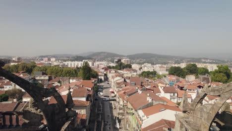 Luftstadtbild-Der-Innenstadt-Von-Braga,-Während-Die-Drohne-Rückwärts-Zwischen-Den-Türmen-Der-Se-De-Braga-Fliegt