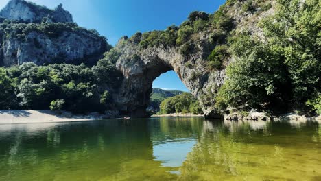 People-kayaking-on-famous-river-in-front-of-cliffs-vallon-pont-d'arc-in-Ardeche