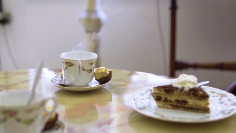medium-close-up-of-coffe-steaming-with-fresh-cake-served-in-vintage-rustic-restaurant-slow-motion