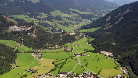 Una-Foto-De-Un-Dron-De-Un-Pequeño-Pueblo-Krimml-Con-Casas-Y-Un-Valle-De-Los-Alpes-Austriacos-Desde-Arriba,-Austria,-Europa