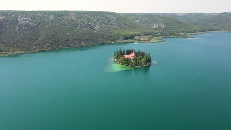 Vista-Aérea-De-La-Isla-Visovac-En-El-Parque-Nacional-Krka-Con-Lagos-Y-Montañas-En-Dalmacia,-Croacia