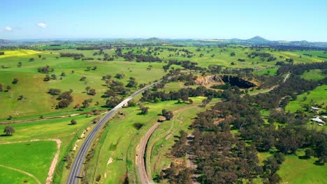 Vista-Panorámica-De-Una-Carretera-Asfaltada-En-El-Paisaje-Verde-Con-Un-Pozo-De-Agua-En-Australia