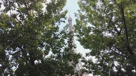Toma-De-La-Torre-Eiffel-A-Través-De-árboles-Durante-El-Día-Con-Cielo-Azul-Después-De-La-Situación-Covid,-París-Francia