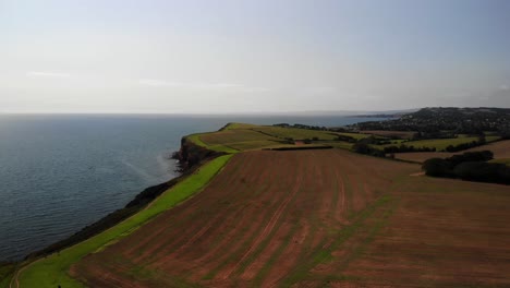 Aerial-Over-Cultivated-Farmland-Beside-English-Channel-In-Devon