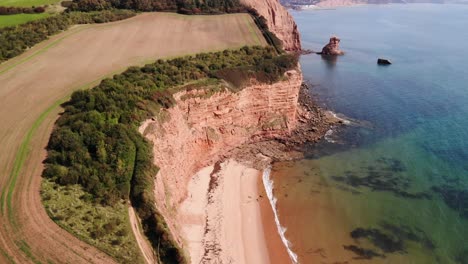 Aerial-Over-Empty-Beach-Beside-Coastal-Cliffs-Near-Ladram-Bay