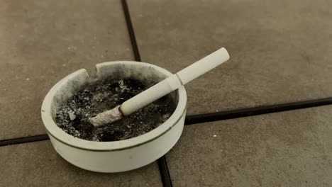 Cigarette-Burning-Ash-Flick-In-Ashtray-Close-Up