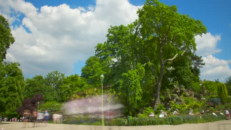 Timelapse-of-Parc-Monceau-with-people,-green-trees-and-cloudy-blue-sky---4k