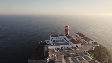 Aerial-approaching-Cabo-de-Sao-Vicente-lighthouse-and-convent,-Sagres,-Algarve
