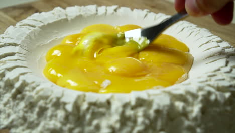 CU-Pasta-making:-egg-yolks-are-beaten-inside-a-well-of-flour