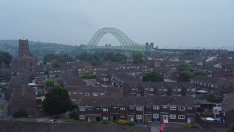 British-Northern-Runcorn-bridge-suburban-residential-townhouse-neighbourhood-aerial-view-descending-dolly-right