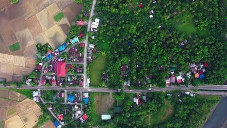Top-Down-View-Of-Village-Surrounded-By-Lush-Vegetation-And-Fields-In-Saint-Bernard,-Southern-Leyte,-Philippines---aerial-drone-shot