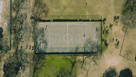 AERIAL---Basketball-court-in-park,-Buenos-Aires,-Argentina,-top-down-rising-shot
