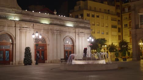 Fuente-Icónica-Y-Edificio-Iluminado-Del-Mercado-Central-En-La-Plaza-Mayor,-Castellon-De-La-Plana,-Castello,-España-Por-La-Noche