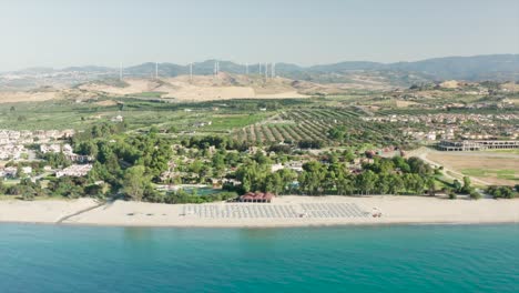 Vista-Aérea-Del-Hermoso-Mar-Y-Playa-Con-Sombrilla-En-Un-Día-Soleado,-Simeri-Mare,-Calabria,-Sur-De-Italia