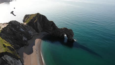 Morning-Aerial-Over-Durdle-Door-With-Calm-Turquoise-Waters