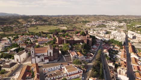 Aerial-wide-view-of-Silves-townscape-and-Moorish-Castle,-Algarve-Portugal