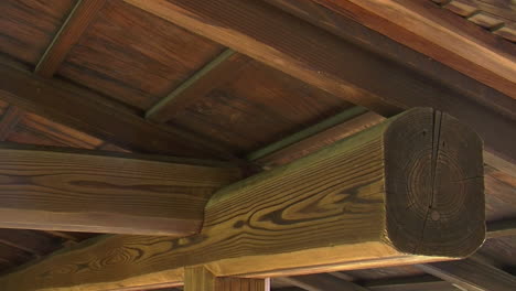 Close-up-of-wooden-beams-and-rafters-under-roof-of-Japanese-building