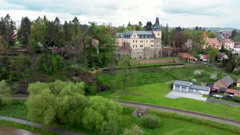 aerial-view-of-a-castle-in-Zruc-nad-Sazavou,-Czechia-with-Sazava-river-in-front