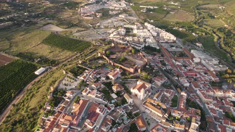 Aerial-birds-eye-view-above-the-town-of-Silves,-showing-the-countryside-surrounding-the-town,-bright-summers-day