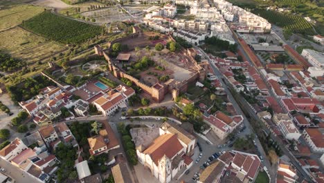 Aufsteigende-Antenne-über-Der-Kirche-Und-Dem-Schloss-In-Sils,-Portugal
