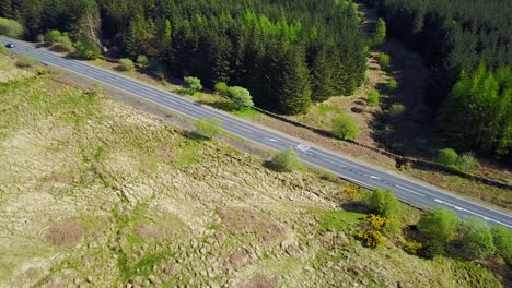 Car-driving-along-Scottish-country-road.-Aerial-view
