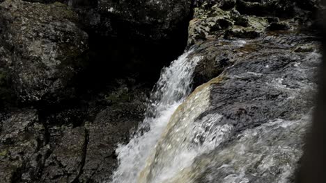 Natürlicher-Wasserfall,-Der-Kaltes-Flusswasser-Schnell-über-Braune-Moosige-Felsen-In-Rauer-Wildnis-Mit-Blasen-Und-Plätschern-Gießt