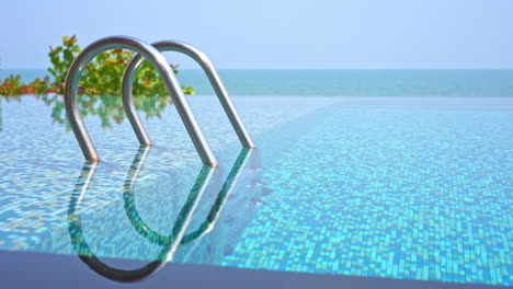 Close-up-view-of-empty-resort-pool-with-ocean-in-background