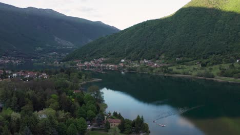 Drone-Volando-Sobre-El-Lago-Endine-Con-Las-Montañas-Al-Fondo,-Lombardía,-Italia