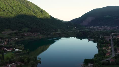 Drone-Volando-Sobre-El-Lago-Endine-Con-Las-Montañas-Al-Fondo,-Lombardía,-Italia