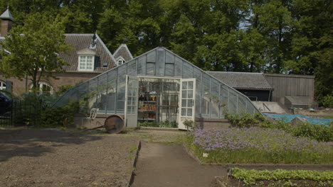 Tilt-down-to-glass-greenhouse-in-kitchen-garden