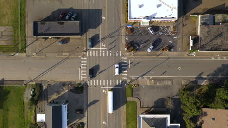 Top-View-Of-Traffic-Moving-At-The-Crossroad-In-A-Small-Town,-drone-top-down