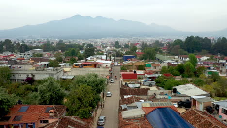 Rising-drone-shot-of-San-Cristobal-de-las-Casas-Mexico-with-mountains-in-the-background,-streets-and-buildings