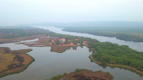 Goa-Divar-Isla-Drone-Pasando-De-Cocoteros-Vacaciones-Mercure-Goa-Devaaya-Cielo-Reflejo-En-El-Agua-Agua-Quieta