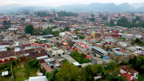 Rotating-drone-shot-of-San-Cristobal-de-las-Casas-Mexico,-streets-and-buildings-and-mountains-in-the-background