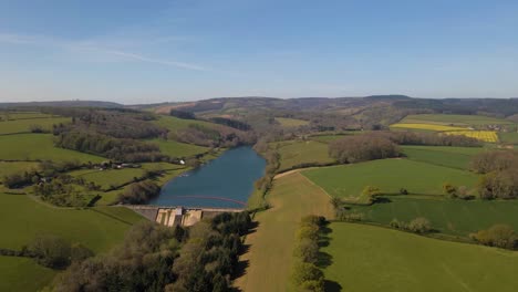 4K-flying-over-hawkridge-reservoir,-drone-moving-forward-over-the-green-tree-in-front-of-the-water-dam-wall,-60fps