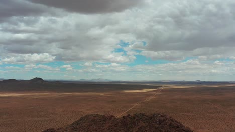 Die-Mojave-Wüste---Ziehe-Die-Luftaufnahme-Zurück,-Um-Einen-Kegelförmigen-Berg-Zu-Enthüllen,-Der-Die-Landschaft-Dominiert