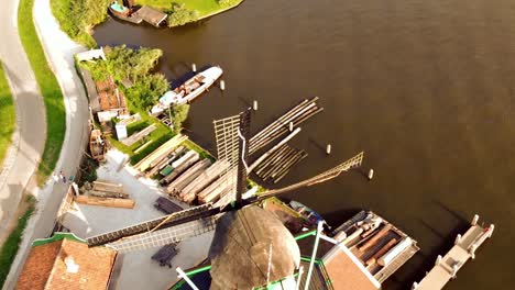 Windmills-riverside-in-Zaanse-Schans,-The-Netherlands---Aerial-top-fly-over