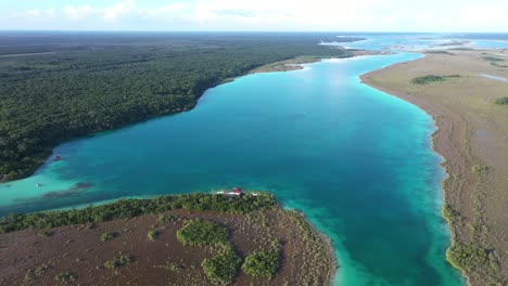Aerial-view-of-Bacalar-Lake,-big-tropical-lagoon-in-countryside-of-Mexico,-wild-landscape,-turquoise-water-and-rainforest,-drone-shot