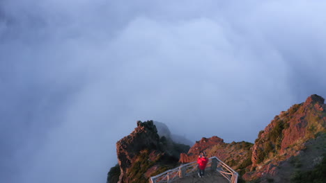 Drone-aerial-footage-of-a-man-on-a-viewpoint-at-Pico-do-Areeiro,-with-cloud-inversion-on-the-island-of-Madeira