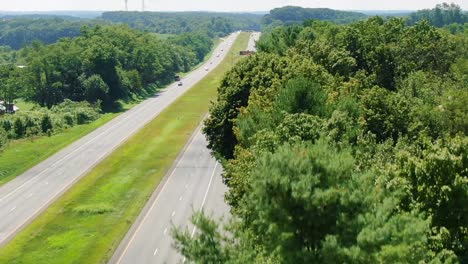 Highway-in-Baltimore-with-few-cars-surrounded-by-green-fields-and-trees