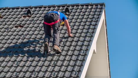 Professional-male-roofer-climbs-down-the-roof
