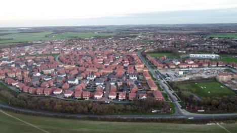 Aerial-dolly-shot-showing-the-landscape-over-a-rural-village-in-the-English-countryside,-bright-daylight
