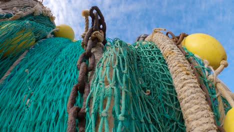 Aufwärtsansicht-Des-Grünen-Fischernetzes-Mit-Ketten-Und-Gelben-Bojen