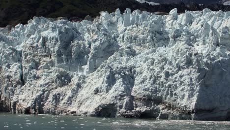 Small-chunks-of-ice-falling-from-the-Margerie-Glacier-in-a-sunny-day,-Alaska