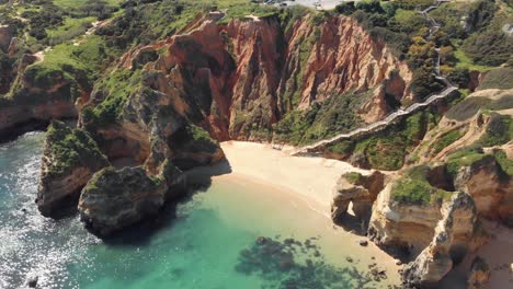 Secluded-sand-beach-surrounded-by-cliffs,-Lagos-,-Algarve
