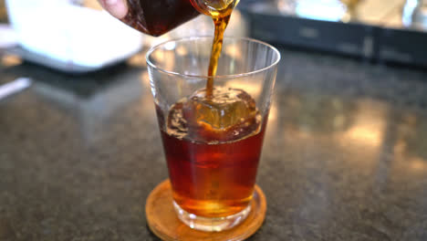 pouring-cold-brew-coffee-or-americano-black-coffee-in-glass-with-ice-cube-in-coffee-shop-cafe-and-restaurant
