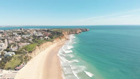 Pristine-Algarve-Shoreline-in-Porto-de-Mós-Beach-near-Lagos-Old-town---Aerial-wide-fly-over-pull-out-shot